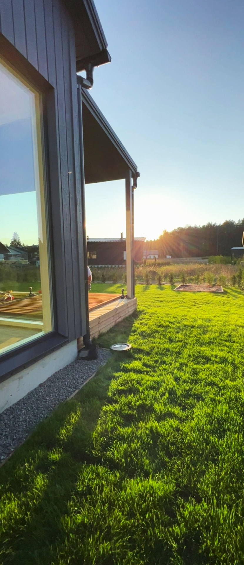 Omakotitalon terassi ja piha auringonlaskussa