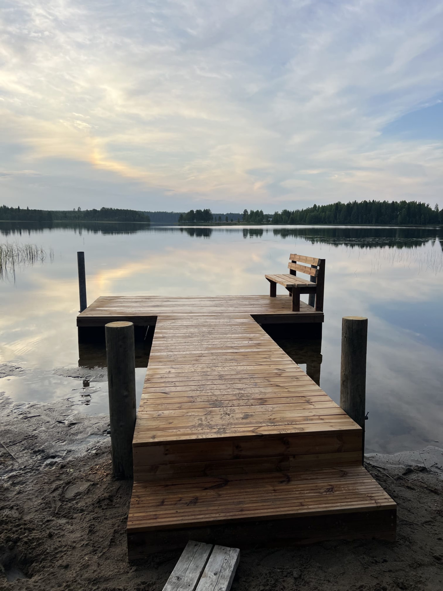 Puinen laituri penkkeineen järven rannassa